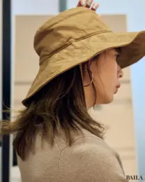 ユニクロ新作アジャスタブルUVカットワイドブリムハットをアジャスターで調整して着用する真知さん