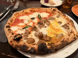 タランテッラ・ダ・ルイジのハーフ＆ハーフピッツァ。左はトマトソースとモッツァレラの王道マルゲリータ、右は半熟卵とポルチーニ茸、サルシッチャがのった濃厚なビスマルク。