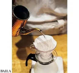 ドリッパーに紙フィルターをセットし、ポットで全体に湯を注ぐ。このひと手間でコーヒーの成分がカットされにくく